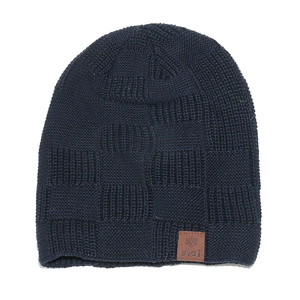 Dettaglio del berretto in maglia blu scuro con motivo a scacchi e patch in pelle applicata