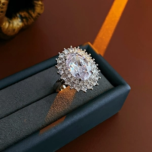 Macro view of oval cubic zirconia ring with double halo setting in a blue velvet box