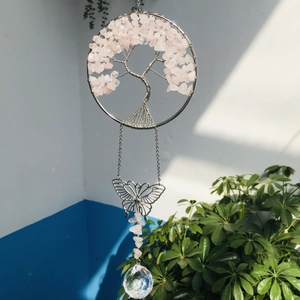 Close-up of tree of life suncatcher with pink crystals, silver butterfly, and faceted ball
