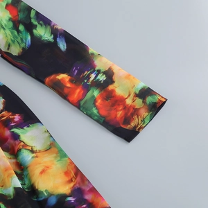 Close-up of floral print sleeve cuff on black polyester fabric with vibrant petal detail