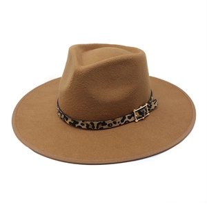 Detail of leopard print ribbon and gold buckle on a brown wool fedora hat with wide brim