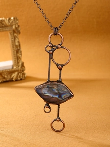 Close-up of vintage bronze geometric necklace with natural labradorite pendant detail