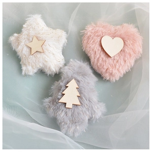 Detailed view of fuzzy plush star, heart, and tree ornaments with gold tinsel and wood