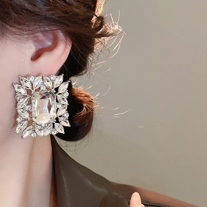Close-up of luxury square rhinestone earrings with marquise crystals on model ear