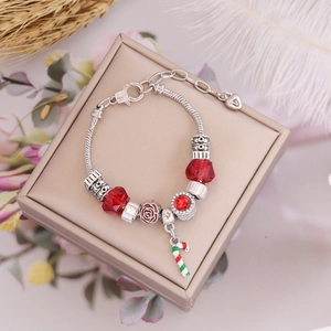 Christmas beaded bracelet with red charms and candy cane pendant on a gift box