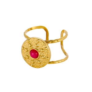 Detail of vintage gold-plated titanium ring with red stone inlay and hammered texture finish