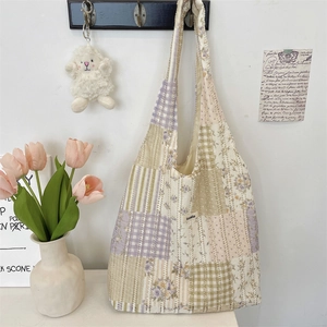 Dettaglio della borsa patchwork Suzakka con motivi floreali, quadri e trame di tessuto