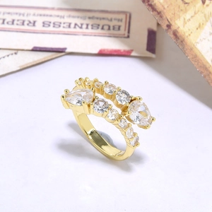 Golden double-row ring with pear-shaped cubic zirconia stones on white background