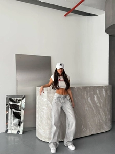 Jean femme taille haute délavé gris à jambe large avec déchirures stylées à l'arrière