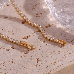 Macro shot of 14K gold plated tennis chain with cubic zirconia and folding clasp