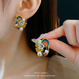 Vintage floral drop earrings with green enamel and white pearls in a golden finish