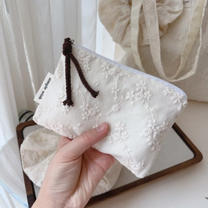 Detailed macro view of cream cotton coin purse with elegant 3D floral embroidery