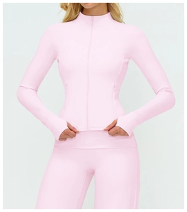 Détail de la manche de veste de yoga rose avec passe-pouce et tissu technique extensible