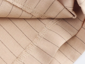 Vue macro du tissu rayé kaki montrant les coutures fines et les détails de texture