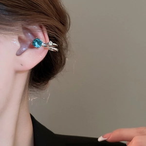 Détail de la manchette d'oreille double argentée avec pierre bleue et strass blancs