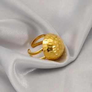 Minimalist 18K gold stainless steel hammered dome ring set on elegant silk fabric
