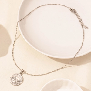 Close-up of silver stainless steel necklace featuring a wave relief pendant and lobster clasp