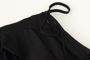 Detail of black camisole straps and textured ribbed fabric with hidden side zipper