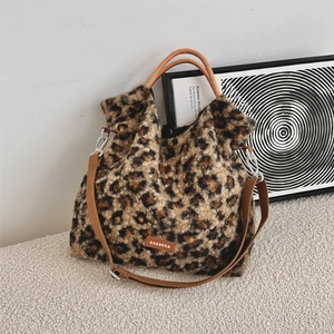 Détail du sac cabas en peluche léopard avec anses orange et bandoulière marron réglable