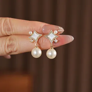 Elegant gold star pearl stud earrings with zircon inlay and white mother-of-pearl detail