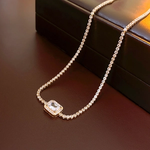 Gedetailleerde weergave van een elegante goudkleurige tennisketting met een centrale zirkonia.