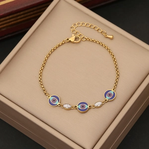Goldenes Evil Eye Armband mit blauen Emaille Anhängern und Zirkon auf einer Schmuckbox