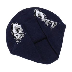 Detailed close-up of dark blue knitted beanie with white and grey wolf ear patterns