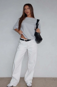 Street style view of white straight-leg denim jeans paired with a gray oversized t-shirt