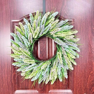 Detailed view of lavender and grain wreath hanging on a rustic wooden front door