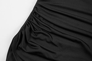Detail of side ruching on slim black knit dress showing texture and stitching