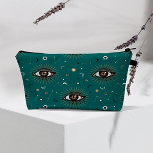 Detailed shot of dark green makeup bag with golden mystic celestial patterns on white stand
