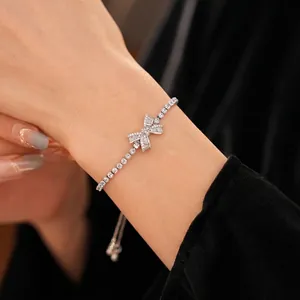 Adjustable silver bow bracelet with sparkling zircons on a model's wrist