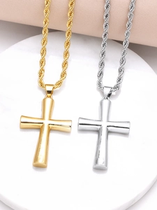Macro shot of polished gold and silver cross pendants with twisted rope chains on display
