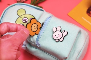 Detail of light blue canvas backpack pencil case with cute cartoon prints on pink background