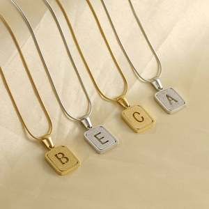 18K gold and silver snake chain necklaces with matte square letter pendants on silk