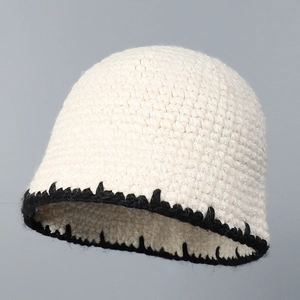 Close-up of white crochet knit bucket hat with black zigzag stitched edge details