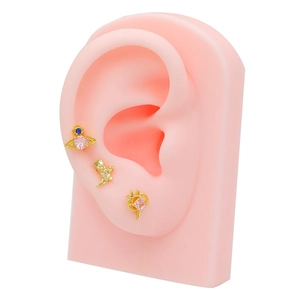 Three-piece gold cartilage earring set featuring planet, boot and star designs with pink stones