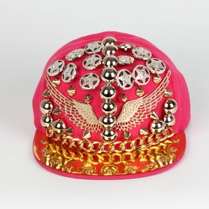 Détail de la casquette punk avec tissu rose, visière dorée et clous en forme d'ailes