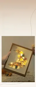 Close-up of handmade seashell frame night light with warm LED lights and wooden texture