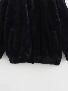 Detail view of the soft faux fur texture and black hem on the flight bomber jacket
