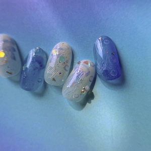 Detailed view of ocean-themed nail stickers with jellyfish patterns and blue glitter
