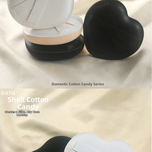 Macro detail of heart and shell-shaped makeup puffs on soft fabric background