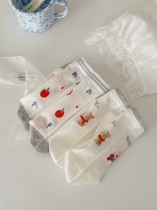 Detail of four pairs of breathable mesh socks with cute bear and apple patterns for kids
