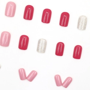 Pink and magenta press-on nails set with silver glitter accents on white background