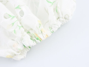 Detailed view of elastic cuffs with delicate floral embroidery and cut-out lace patterns