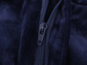 Detailed macro view of dark blue velvet fabric and matching metal zipper on suit jacket