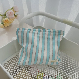 Detail of blue and white striped canvas bag with small fabric label in a grid cart
