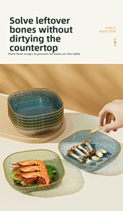 Detail of square hammered glass bone plates with gold rims in blue and green colors