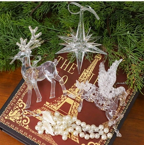 Detailed close-up of acrylic reindeer and star ornaments on a vintage red book