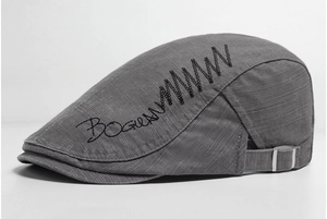 Detail view of cotton flat cap featuring side embroidery and adjustable metal buckle